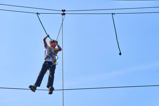 istock Cute school boy enjoying a sunny day in a climbing adventure activity park. 664738888