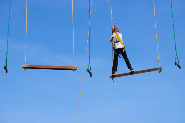 istock Cute school boy enjoying a sunny day in a climbing adventure activity park. 664740942