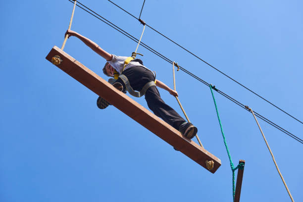 istock Cute school boy enjoying a sunny day in a climbing adventure activity park. 664740962