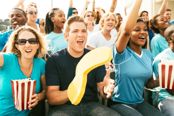 istock Crowd of fans cheering from stadium bleachers 664743544