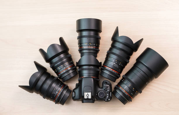istock Digital SLR camera and a few interchangeable manual lenses. The equipment for filmmaking. The wooden table 664747662