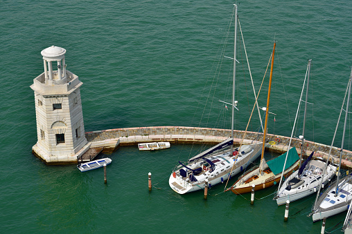 VENICE, ITALY - SEPT 24, 2014: View from above on an yachts in the marina at San Giorgio Maggiore island. More than 10 million tourists visit Venice every year