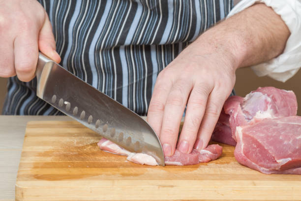 istock Chef's hands with a knife cuts the meat. Healthy eating. 664755966