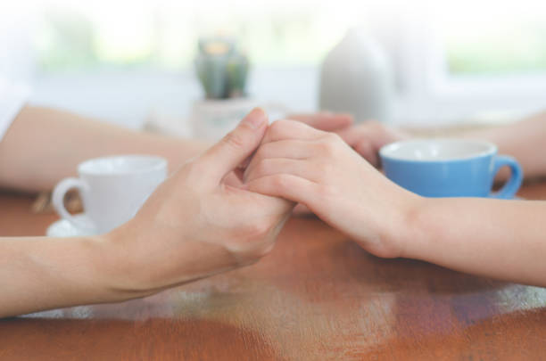 istock Abstract blurred background of lovers couple holding hands on coffee table. 664756806