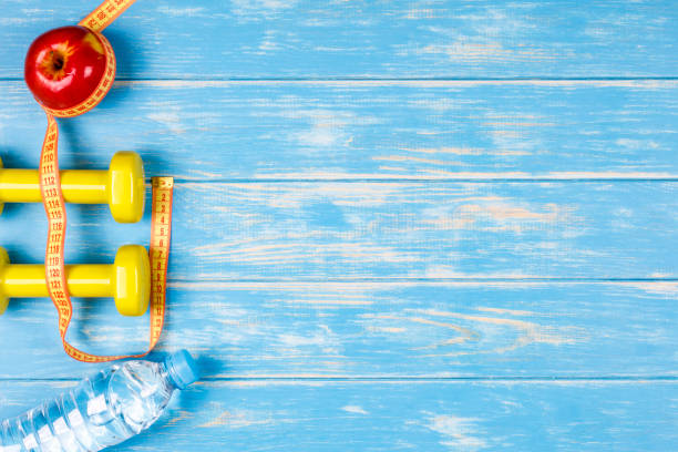 istock Fitness and dieting concept plan on blue wood background. 664768554