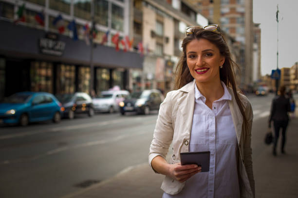 istock Beautiful brunette using digital tablet in the city 664778746