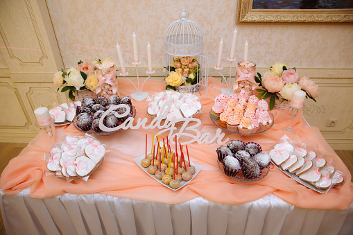 A beautifully curated baby shower celebration with a stunning pastel cake, delicate macarons, and an array of elegant snacks.