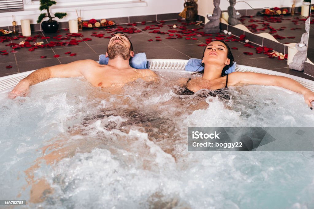 Young attractive couple relax in hot tub Young attractive couple relax in hot tub in spa center Adult Stock Photo