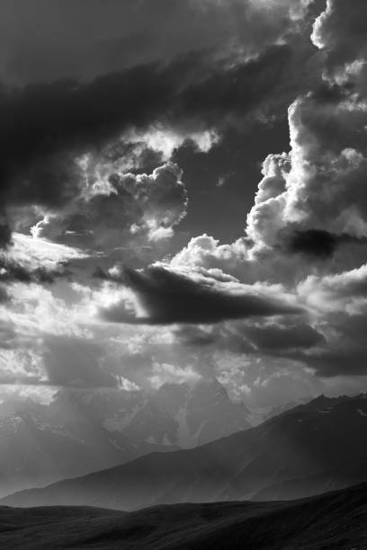 istock Black and white view on mountains in sunlight clouds 664785896