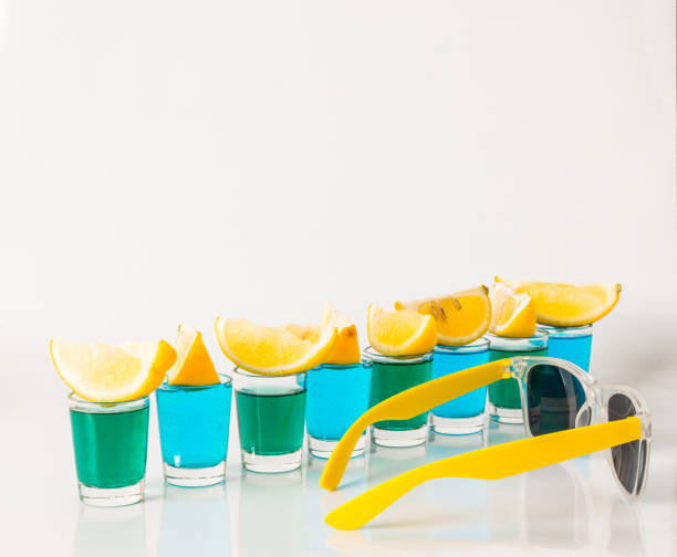 очки с синим и зеленым камикадзе, гламурные напитки, смешанный напиток, налитый в очки, солнцезащитные очки - kamikaze cocktail drink lemon стоковые фото и изображения