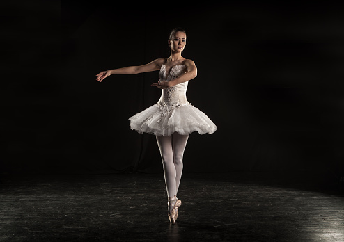 Ballerina performing on dark stage