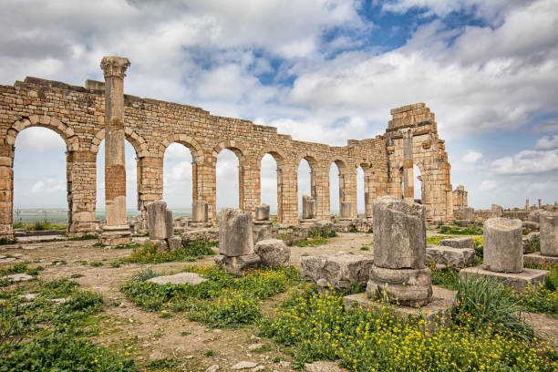 The Tingis Gate, looking back down the Decumanus Maximus in Volubilis on sunny day with few clouds, Morocco.