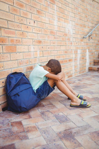 istock Sad boy with his head on his knees 664803678