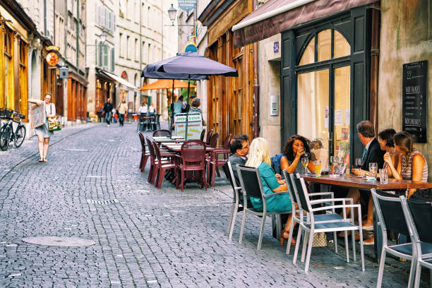 люди отдыхают в кафе под открытым небом на гранд-рю в центре города, швейцария - geneva canton стоковые фото и изображения