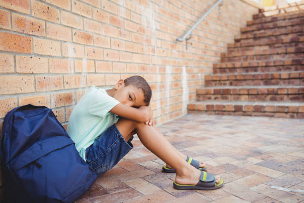 istock Sad boy with his head on his knees 664807378