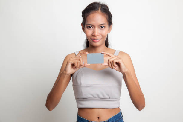 istock Young Asian woman smile with  blank card. 664807436
