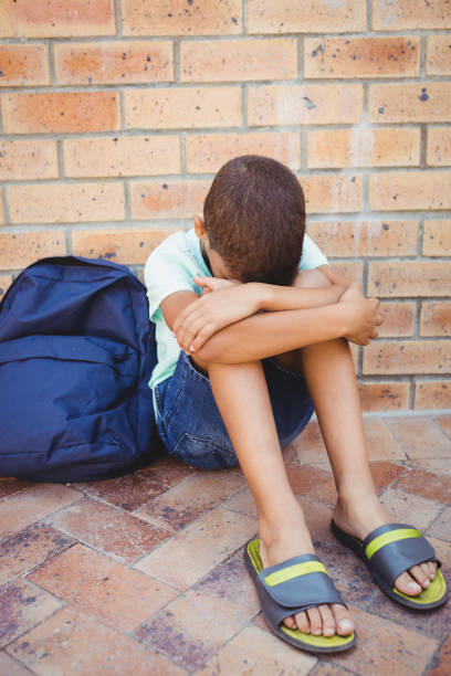 istock Sad boy with his head on his knees 664807792