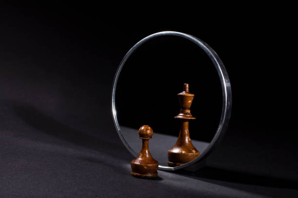 pawn looking in the mirror and seeing a king. - chess king chess chess piece black imagens e fotografias de stock
