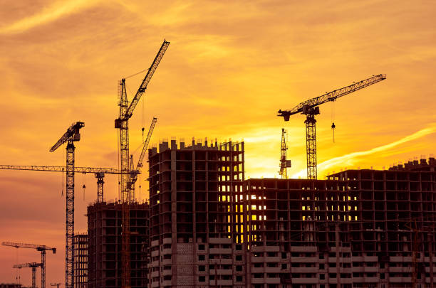 istock Construction site at dusk evening yellow back light, silhouette cranes, sunlight 664814184