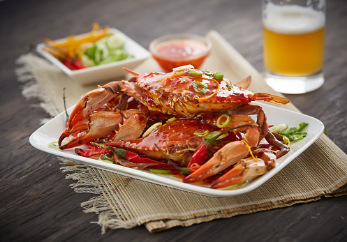 Several Blue Crab on an aged wood surface propped with garnishes, being prepared for a casual meal