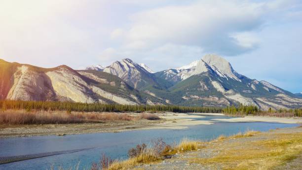 istock lake and mountain snow on top with sun ray effect 664820578
