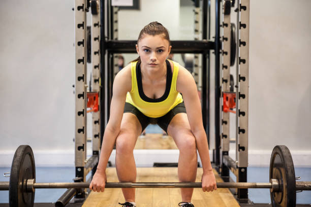 istock Woman lifting barbell and weights 664831854