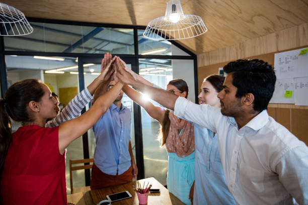 istock Casual colleagues putting hands together 664834580