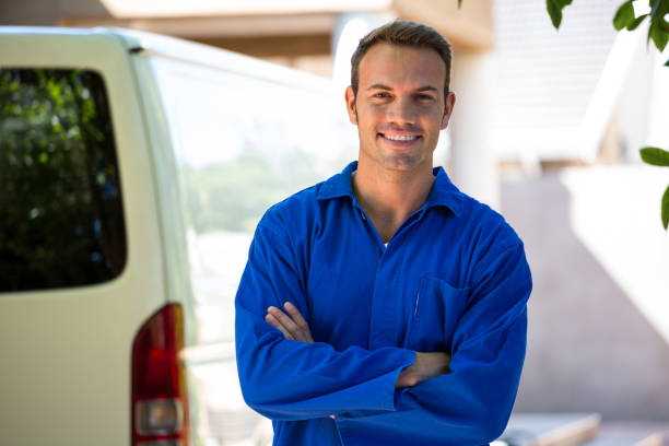 mechanic standing near his car - empreiteiro de reparações imagens e fotografias de stock
