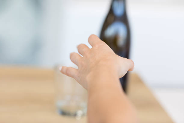 kobieca ręka sięgająca po butelce - table on wine alcoholism zdjęcia i obrazy z banku zdjęć