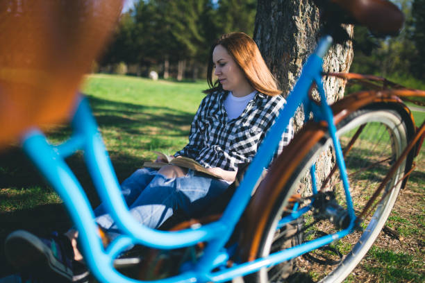 istock Happy young woman relaxing at park with bicycles 664842056
