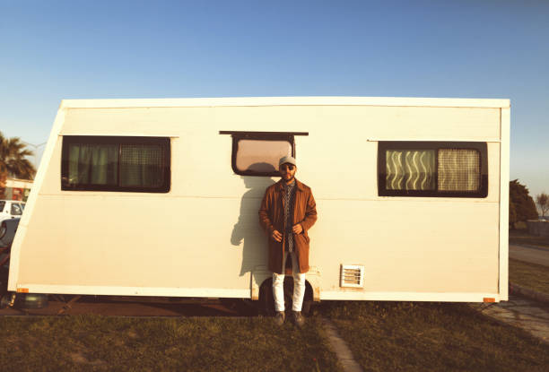 Retro brown striped seventies caravan with flower curtains on a sunny day