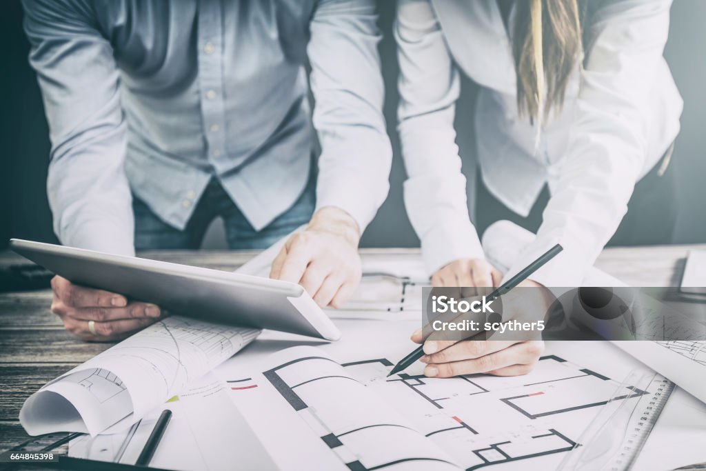 Designers discuss the sketches inside the house. architects architect project interior design designer planning people architecture drawing business plan construction sketch house concept - stock image Architect Stock Photo