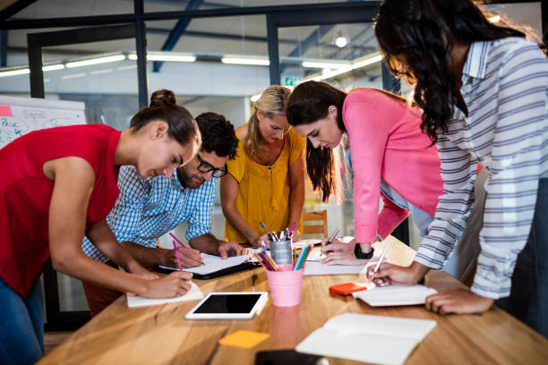istock Casual business team writing in notebooks 664845524