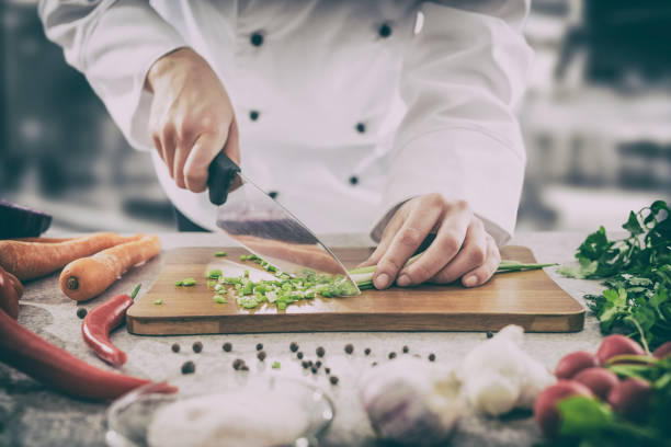 The chef slicing vegetables. chef cooking food kitchen restaurant cutting cook hands hotel man male knife preparation fresh preparing concept - stock image chop stock pictures, royalty-free photos & images