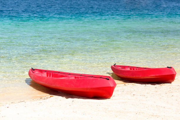 Two red kayaks on the beach, Iririki Island Vanuatu, background with copy space, full frame horizontal composition