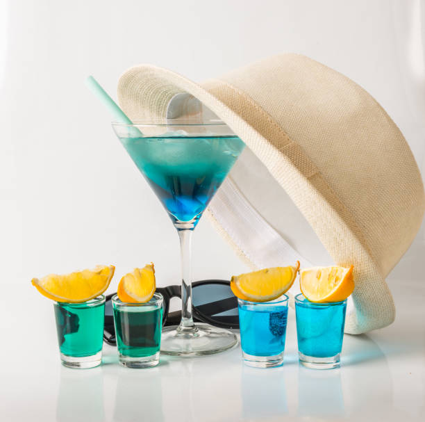 красочный напиток в бокале мартини, сине-зеленая комбинация, четыре напитка в стакане, белая шляпа - kamikaze cocktail drink lemon стоковые фото и изображения