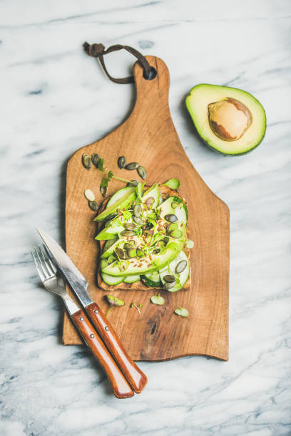 istock Healthy green veggie breakfast concept with sandwich on board 664849086