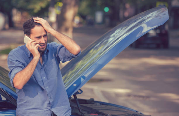 istock young stressed man driver having trouble with his broken car looking in frustration at failed engine 664857824