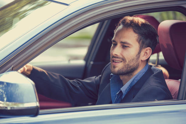 istock Happy man driver smiling driving sport blue car looking in a side mirror 664857852