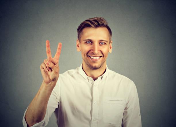 istock young handsome man holding up peace victory 664860468