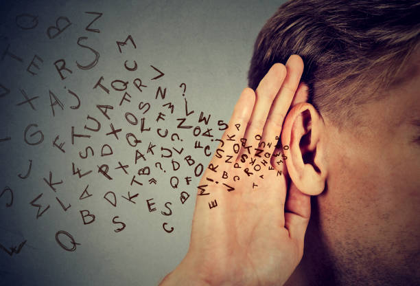 man holds his hand near ear and listens carefully alphabet letters flying man holds his hand near ear and listens carefully alphabet letters flying in isolated on gray wall background Gesturing stock pictures, royalty-free photos & images