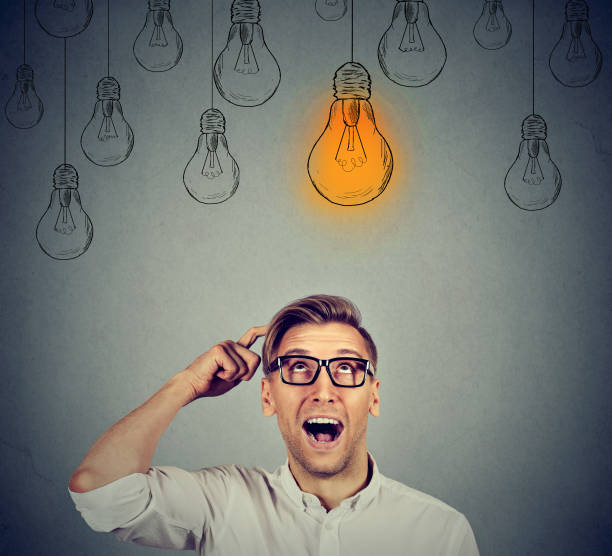 istock Excited happy man in glasses looking up with light idea bulb 664860558
