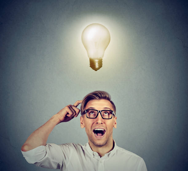 istock Excited happy man in glasses looking up with light idea bulb 664860570