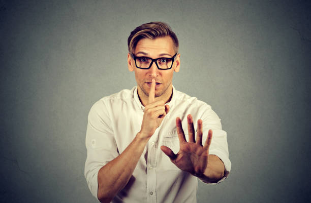 istock young handsome man giving Shhhh quiet, silence 664860588