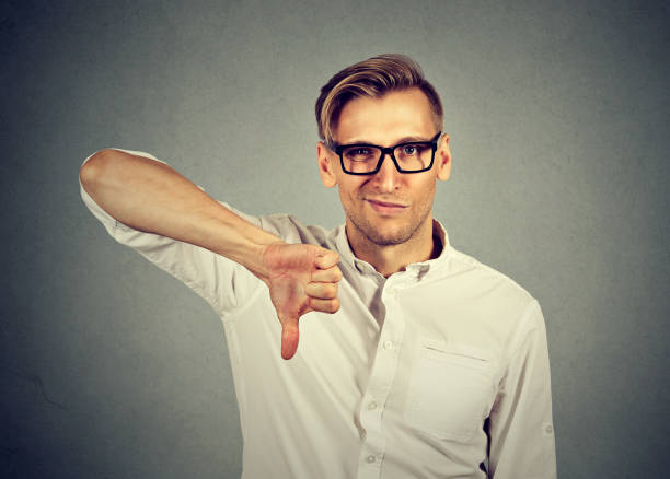 istock angry, unhappy, young man showing thumbs down sign 664860598