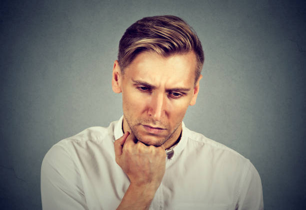 istock Closeup portrait sad young handsome man with worried stressed face expression looking down 664861448