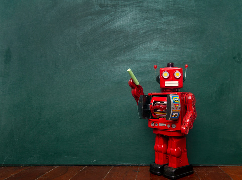 vintage robot writes on black board