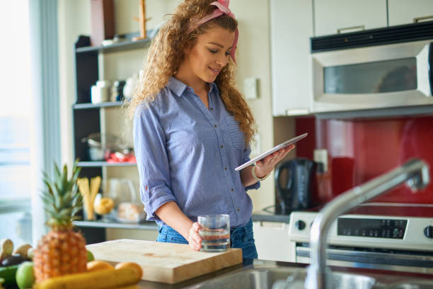 istock Young beautiful woman cooking while working from home 664871060