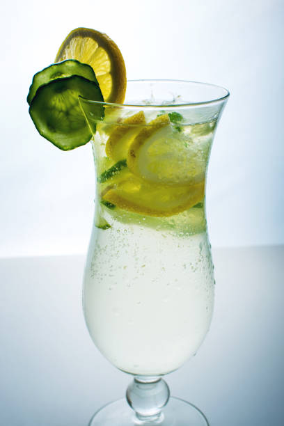 istock Fruit lemonade in hurricane glass with lemon and cucumber. 664874946