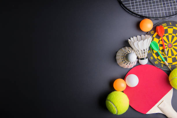 dardos, tenis de mesa raqueta, pelota de ping-pong, volantes, bádminton, raqueta y pelota de tenis sobre fondo negro. concepto del deporte, imagen de espacio de copia de su texto. - rubber dart fotografías e imágenes de stock